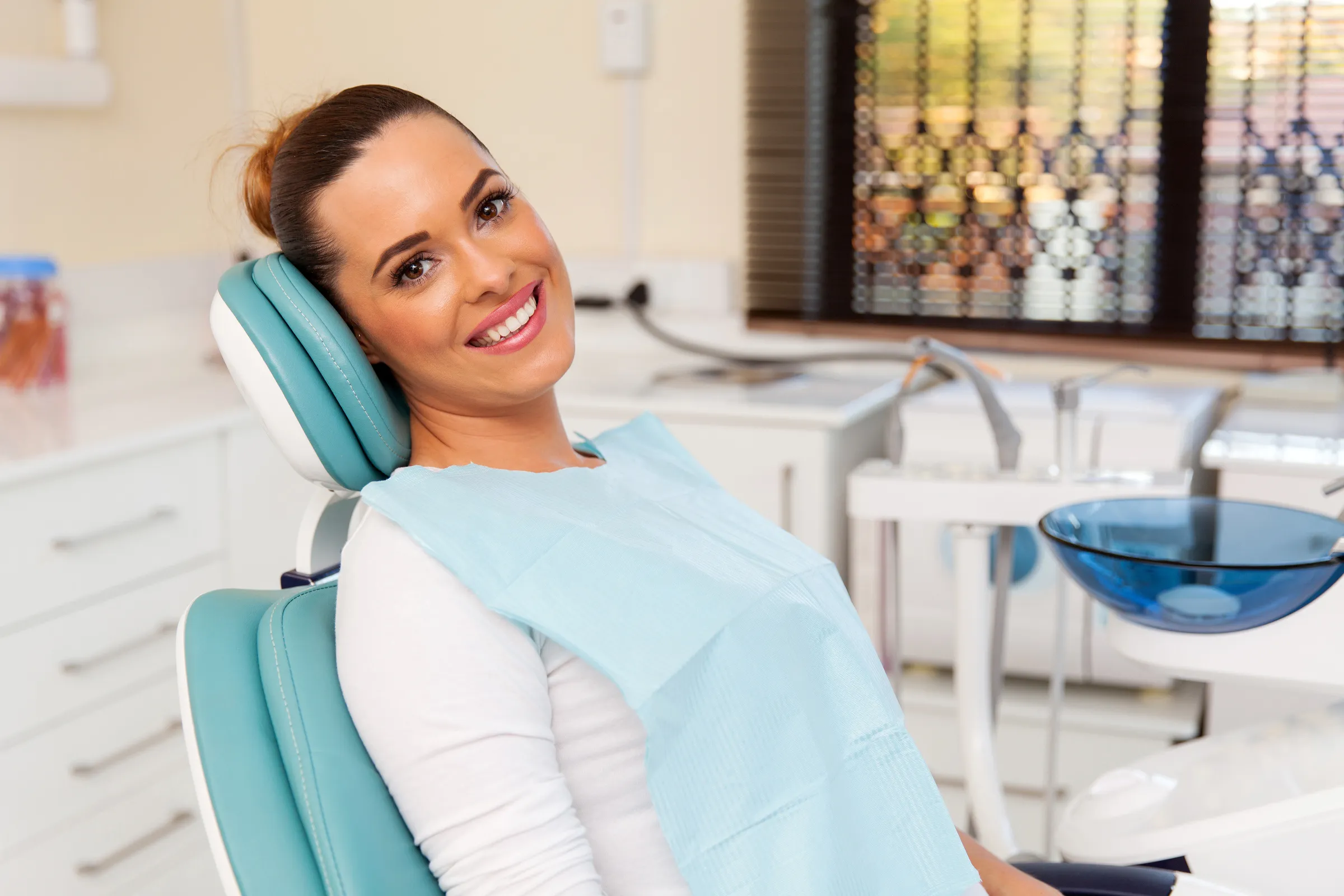 Woman smiling in a dental chair during a checkup