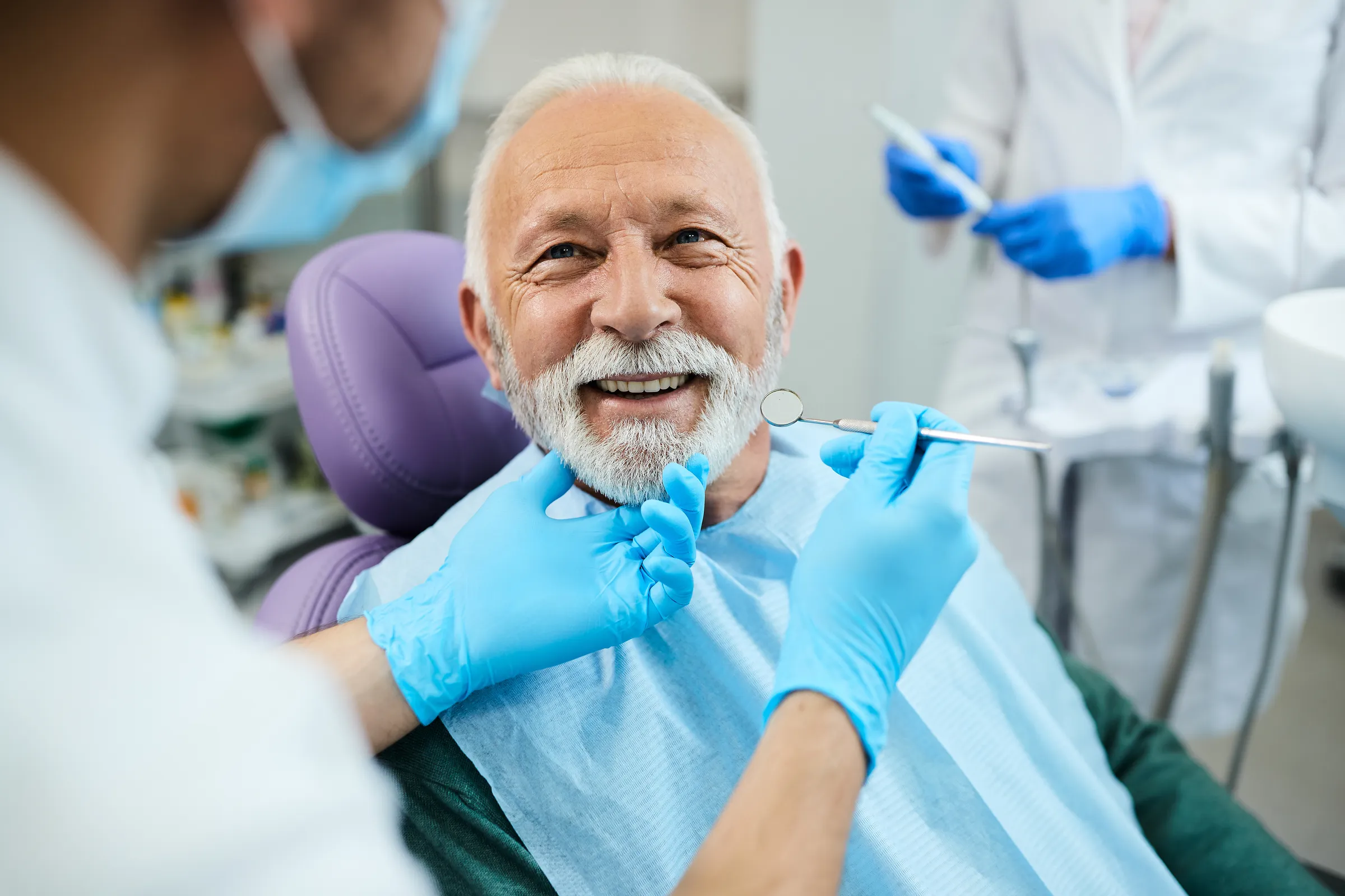 Older man smiling in a dental chair during treatment