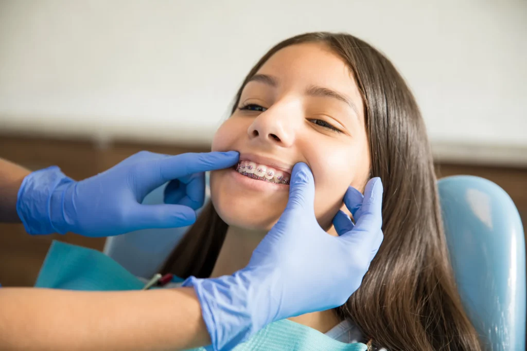 Teenager in a dental chair having her braces checked