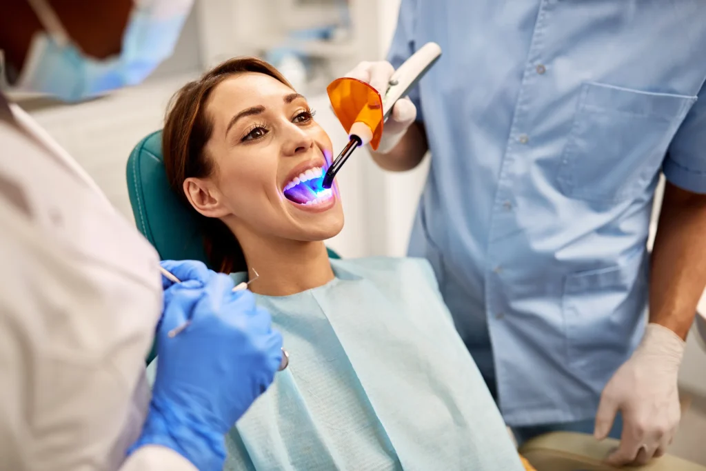 Woman in a dental chair having a filling cured with a curing light