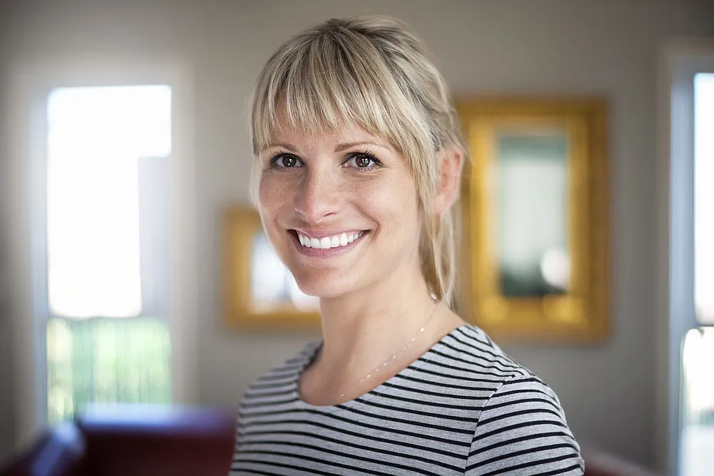 Smiling woman with blonde hair indoors