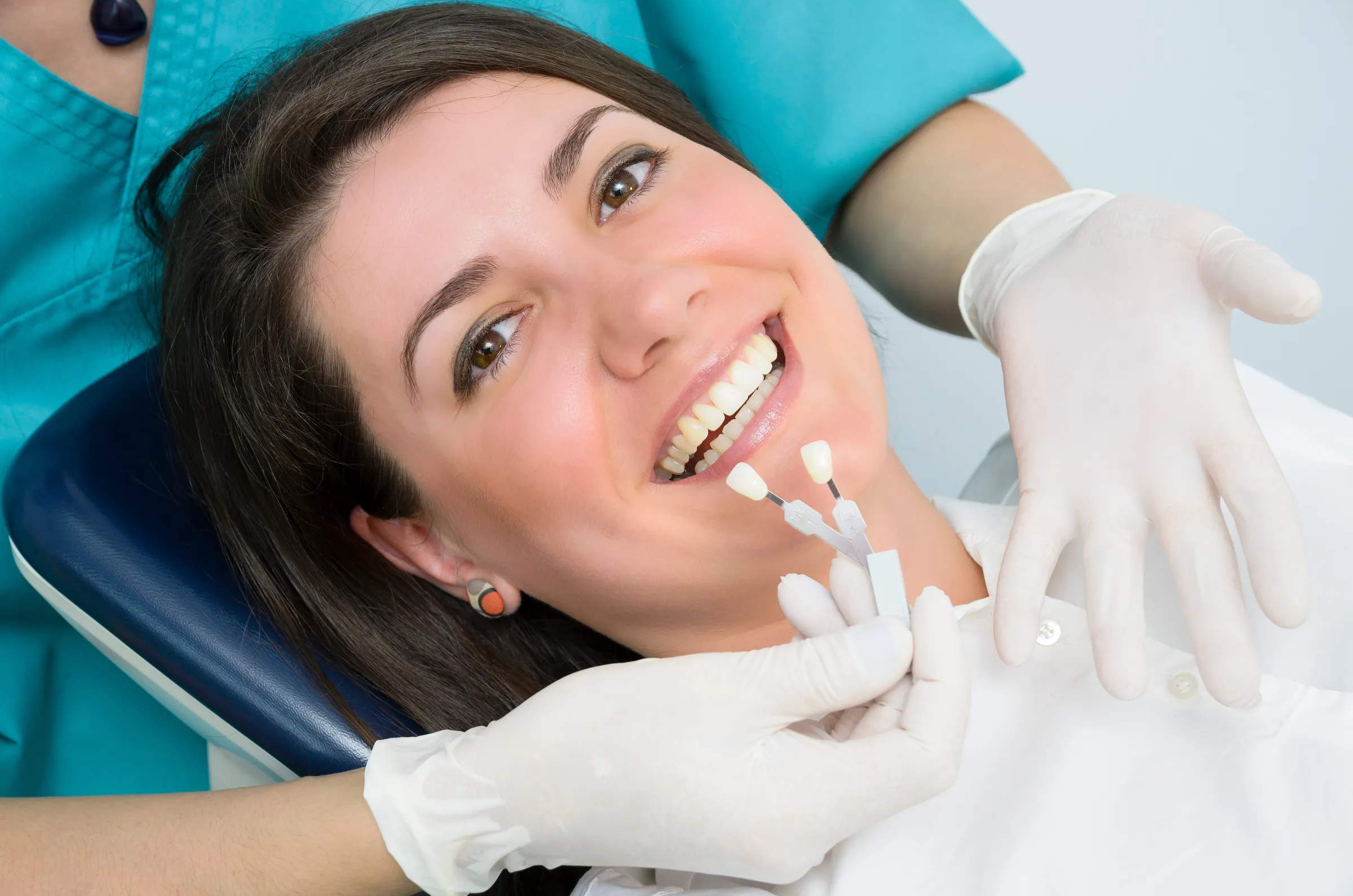 Woman in a dental chair having her tooth shade matched