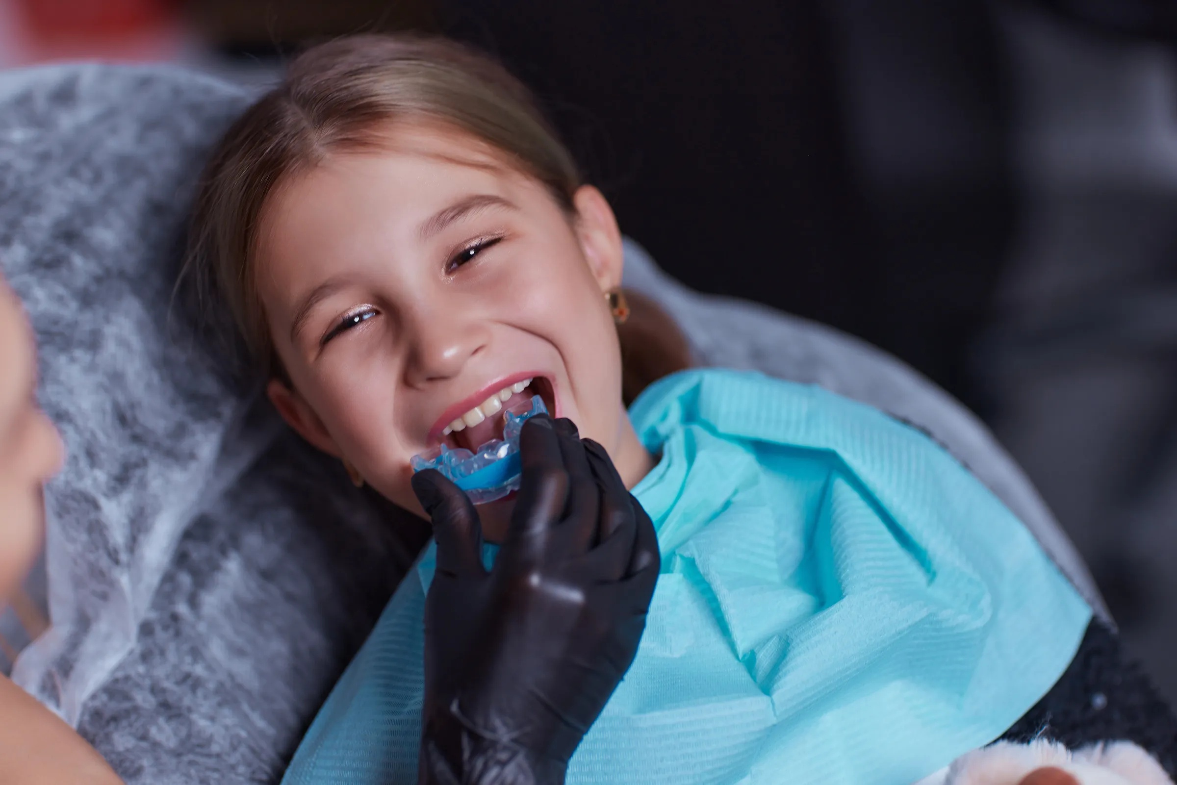 Child in a dental chair having a mouth guard fitted