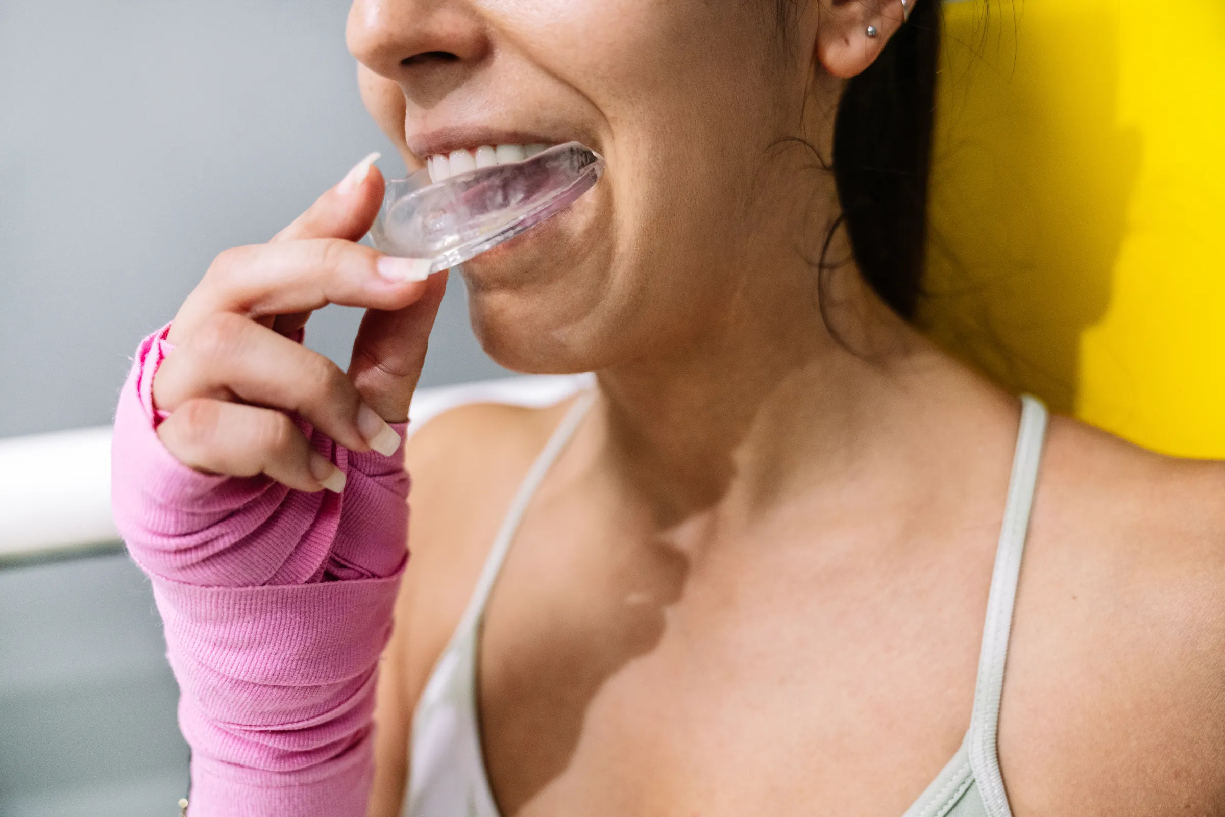 Woman holding a clear night guard to her mouth