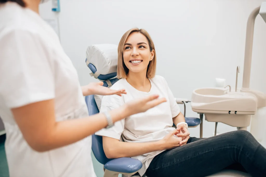Clinician talking with a patient in a dental chair