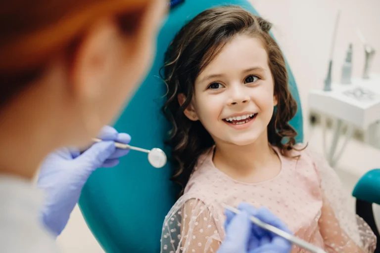 Young girl smiling in a dental chair during a checkup
