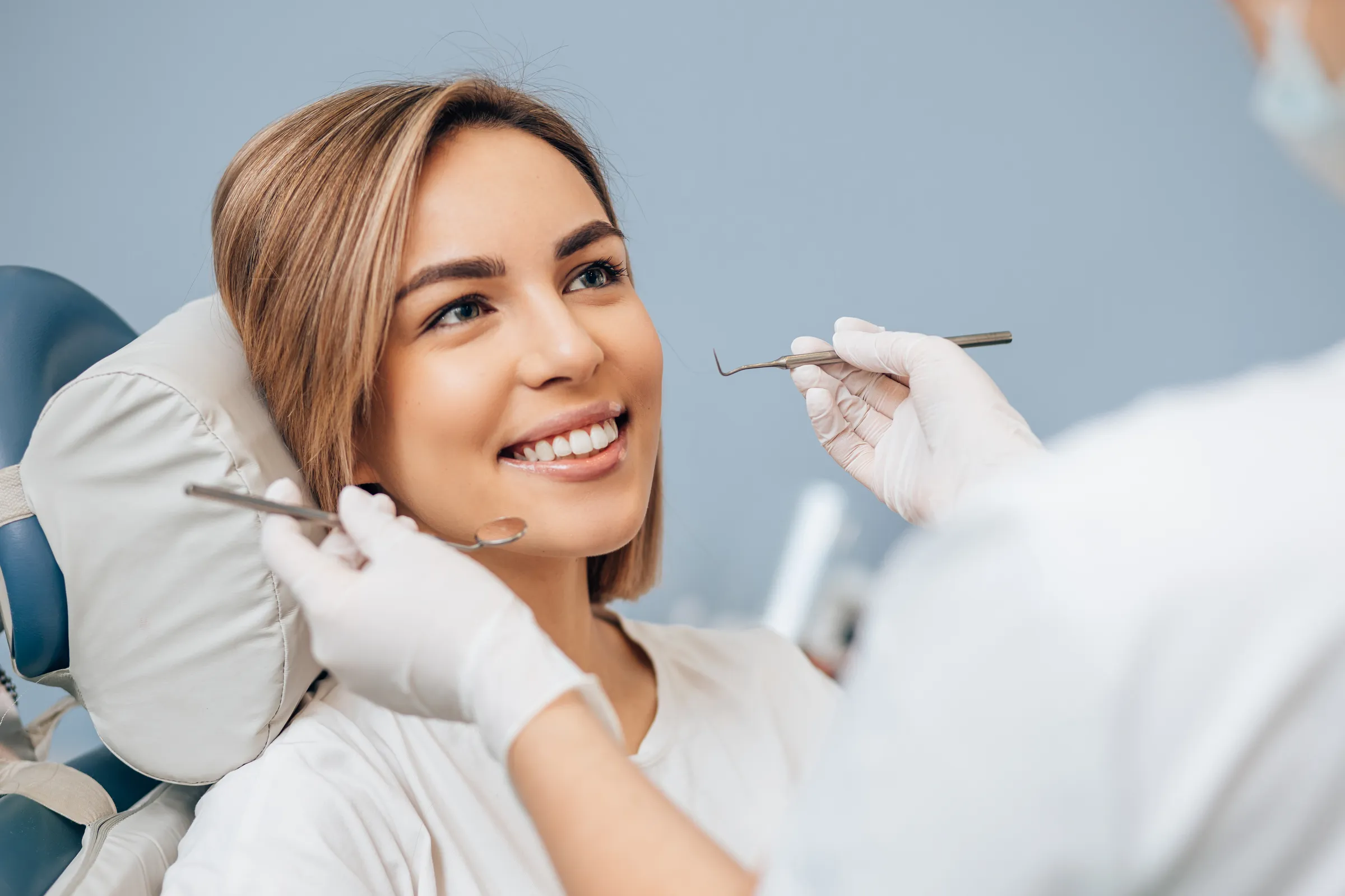 Woman smiling in a dental chair during a cleaning
