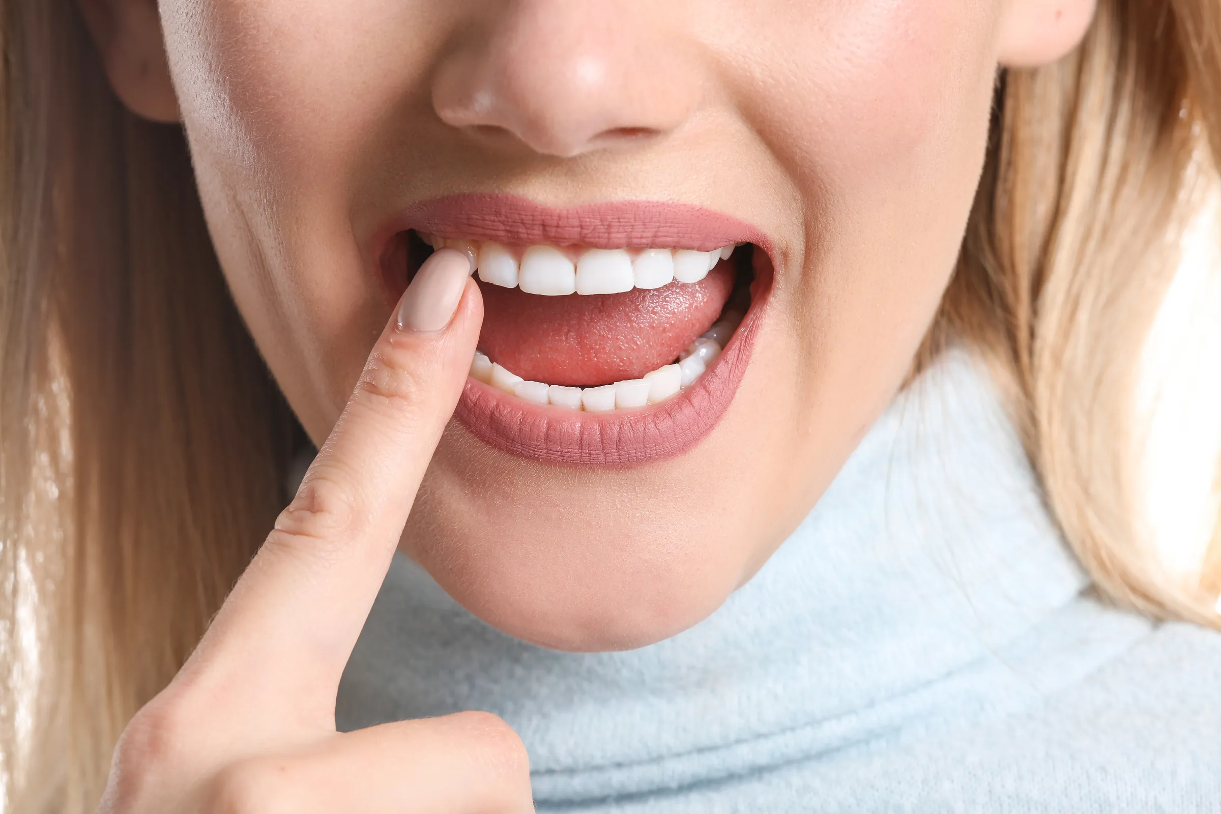 Woman pointing at her gums