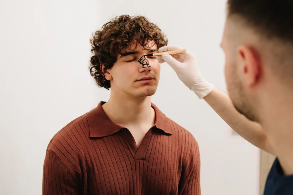 Man having his face marked before a facial treatment
