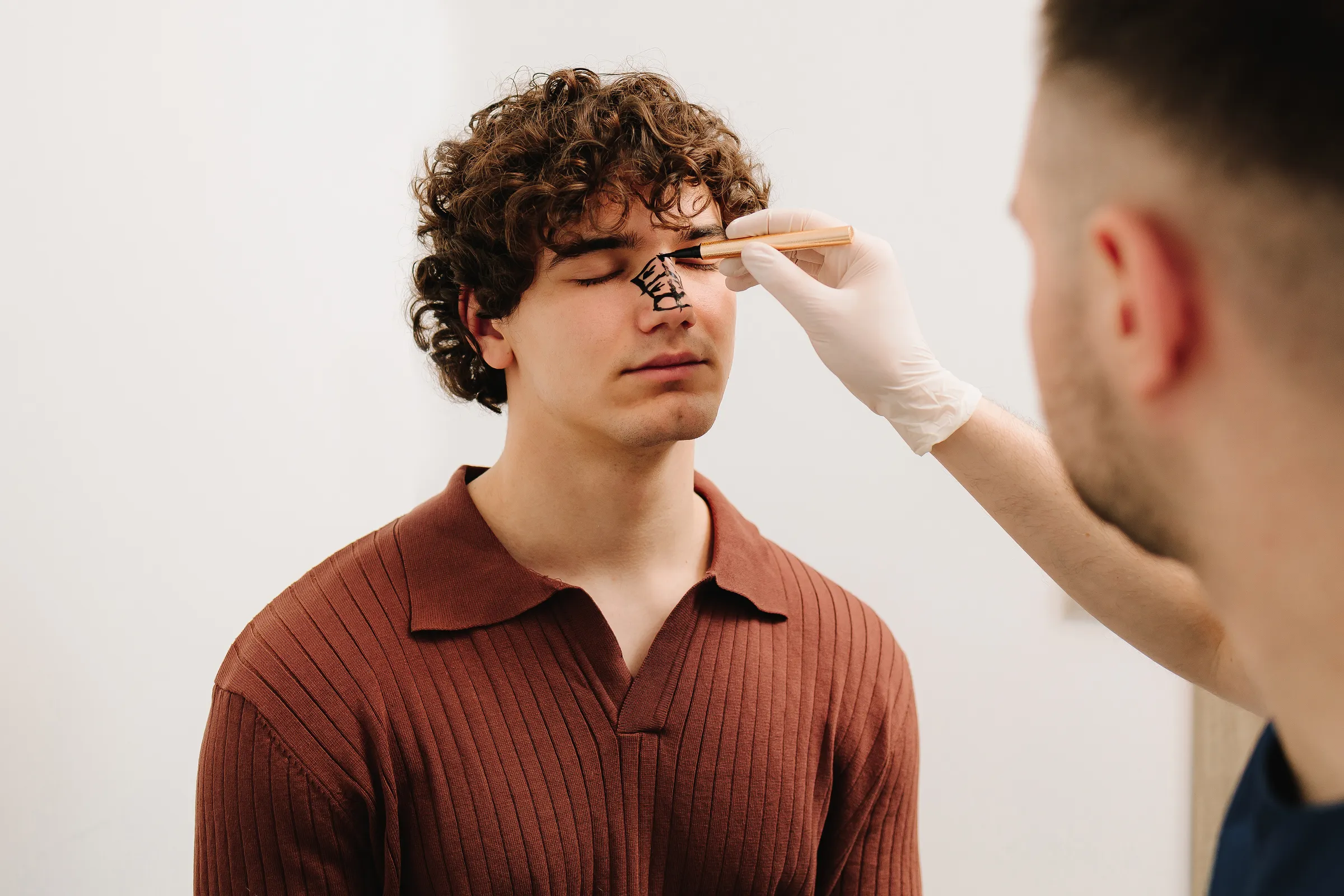 Man having his face marked before a facial treatment