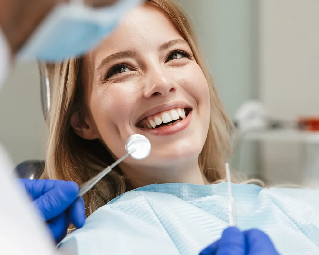 Woman smiling in a dental chair during an examination