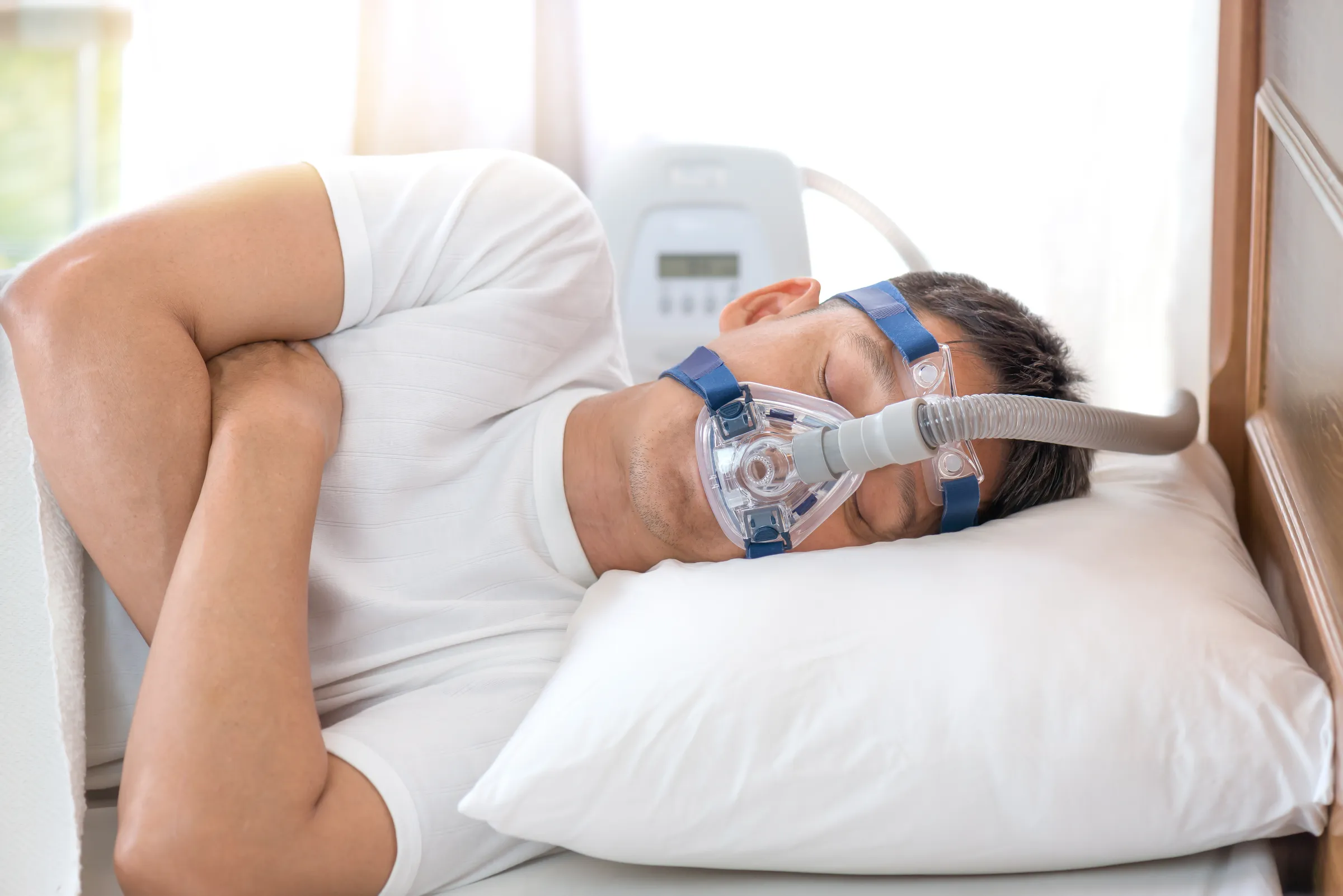Man sleeping wearing a CPAP mask