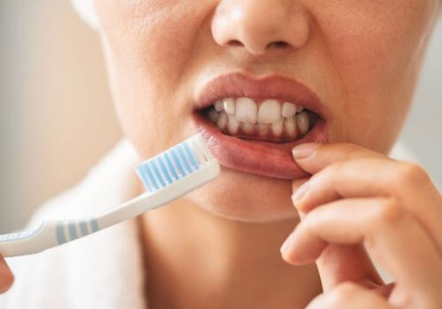 Woman's gums showing irritation after tooth brushing too hard