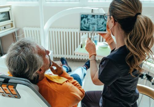 Dentist looking at x-rays with client