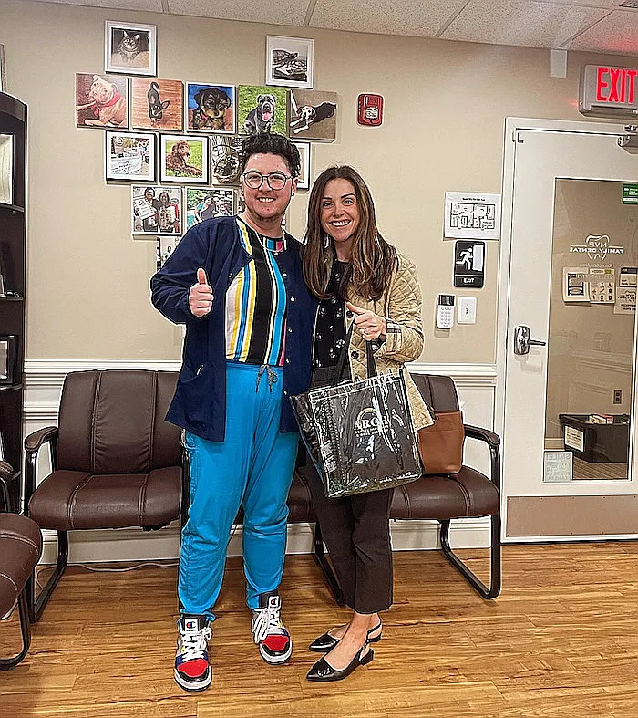 A patient giving a thumbs up beside a team member in the waiting room