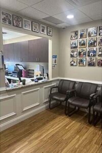 Reception desk and waiting area with patient photographs on the wall