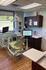 Operatory with a green dental chair beside a window