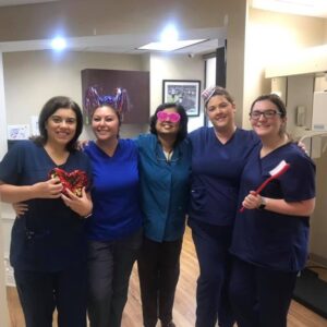 Five team members in scrubs holding chocolates