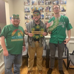 Three team members in green St Patrick's Day outfits