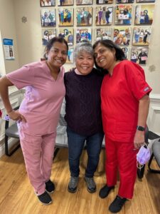Three team members in colored scrubs in the office