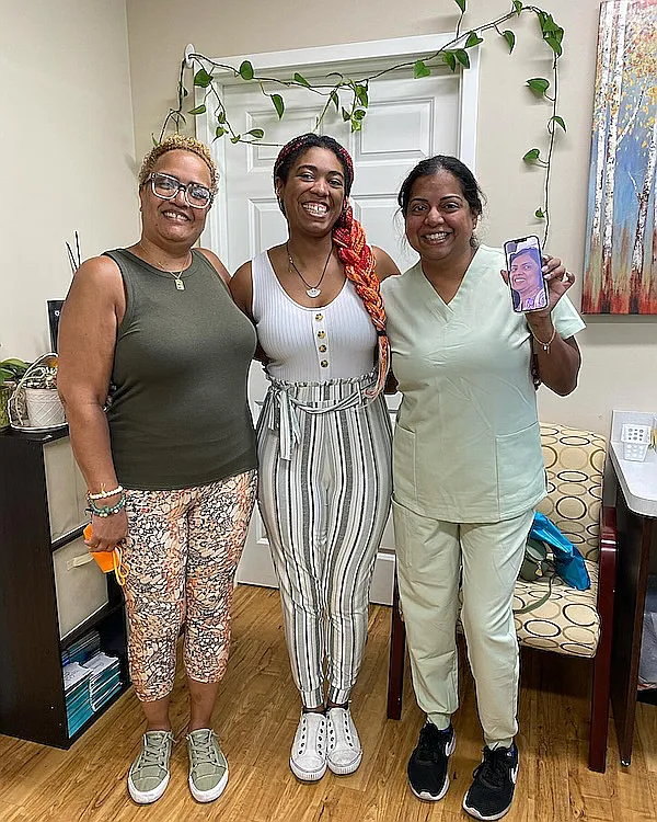 Three women standing together in the practice reception