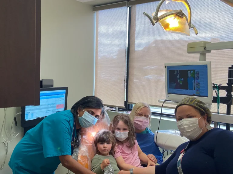 Dental team members with two young children and their family in a treatment room at MVP Family Dental