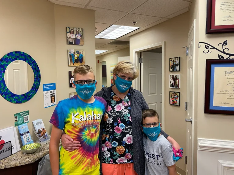 Family of three in face masks smiling together at MVP Family Dental