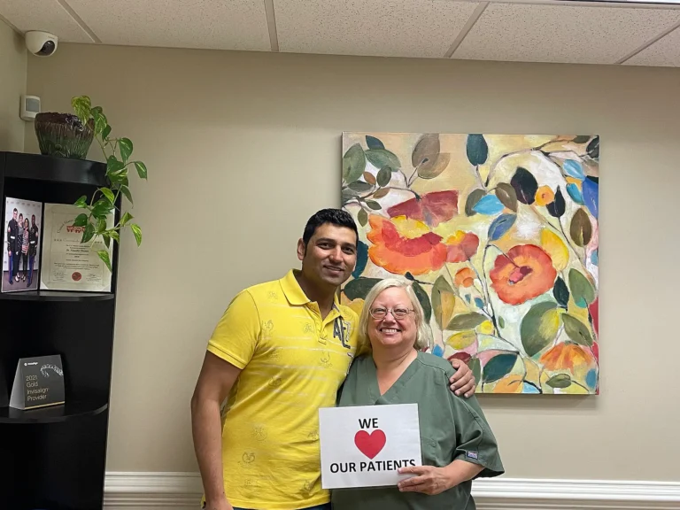 Patient and team member holding a We Love Our Patients sign at MVP Family Dental
