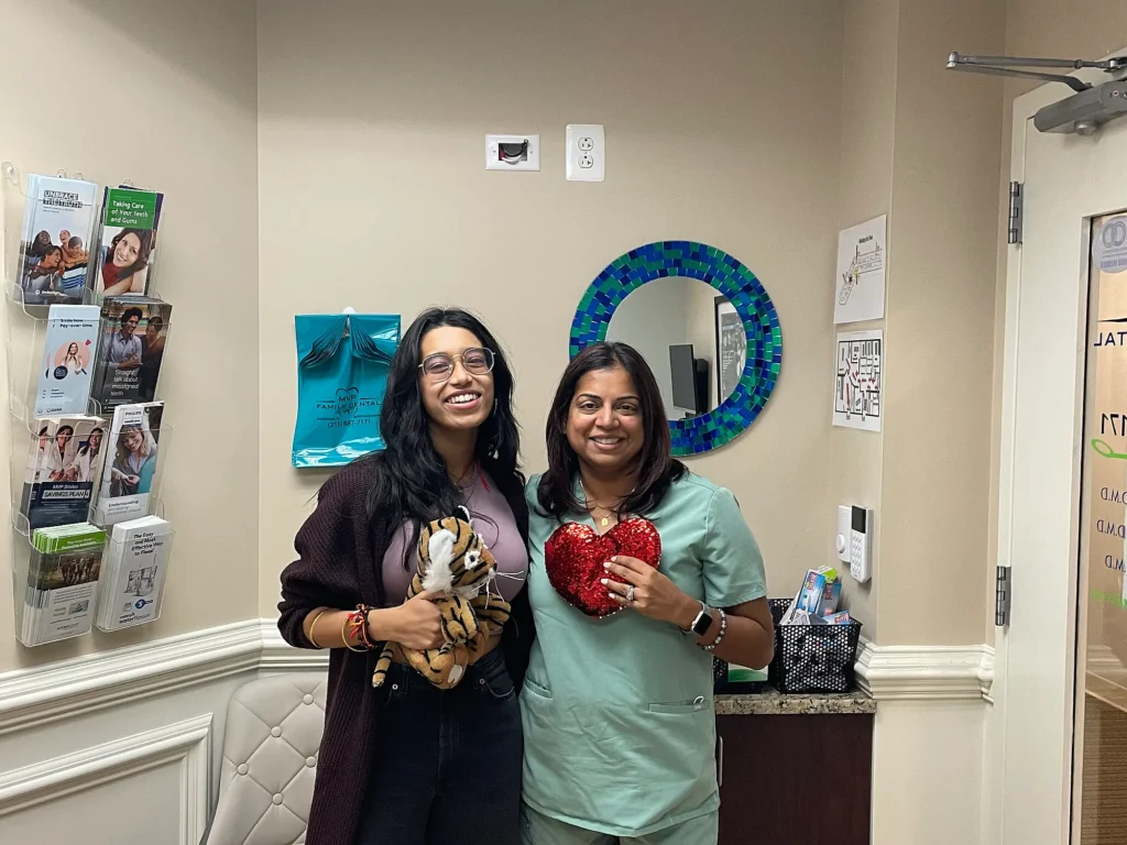 Patient and dental team member holding heart-shaped gifts at MVP Family Dental