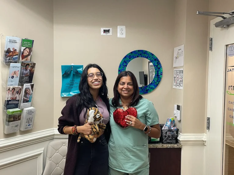 Patient and dental team member holding heart-shaped gifts at MVP Family Dental