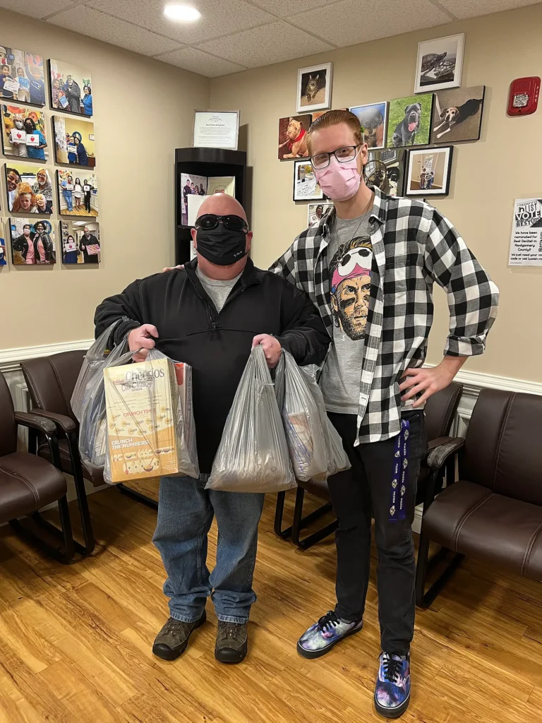 Two patients holding gift bags in the MVP Family Dental waiting room