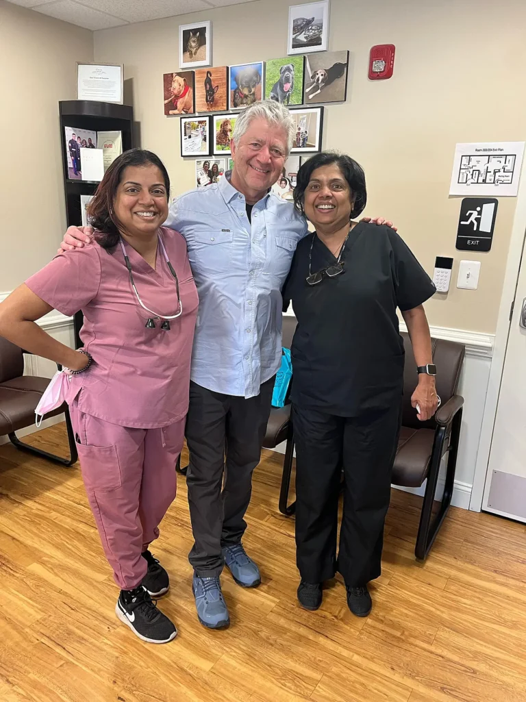 Patient standing between two MVP Family Dental team members in scrubs in the waiting room