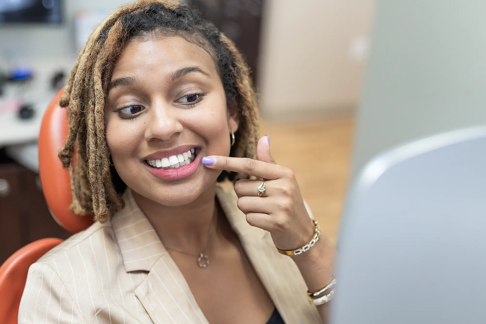 Patient smiling and pointing at her front teeth
