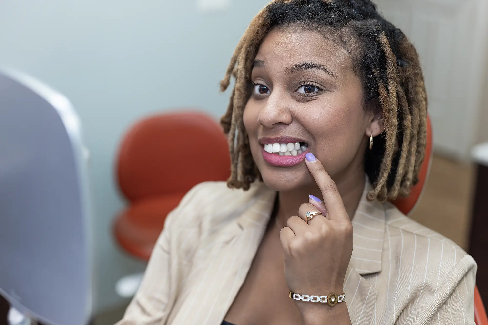Patient smiling and pointing at her teeth