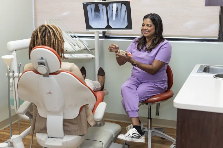 Dr. Priya Mathew reviewing dental X-rays with a patient
