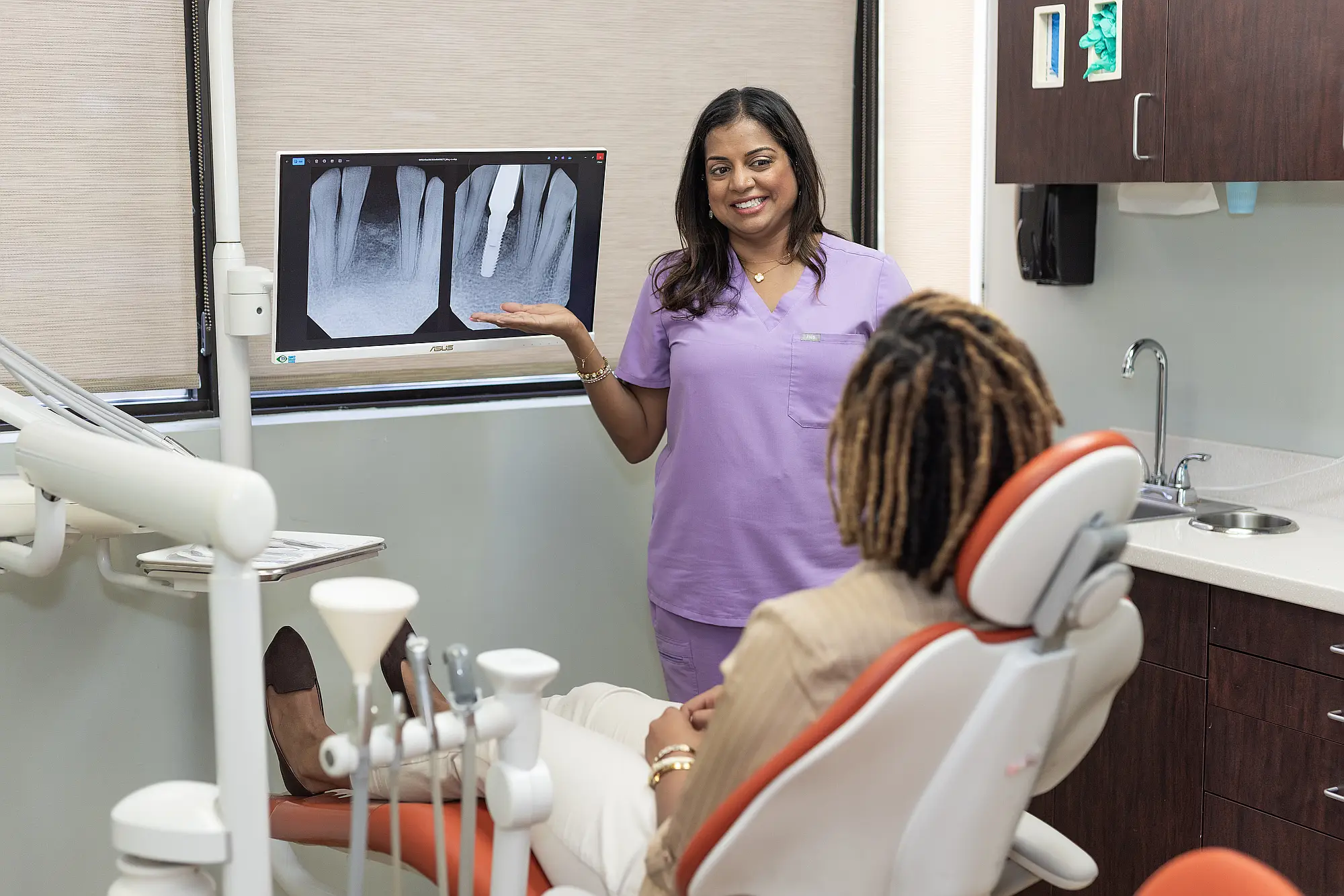 Dr. Priya Mathew presenting dental X-rays to a patient