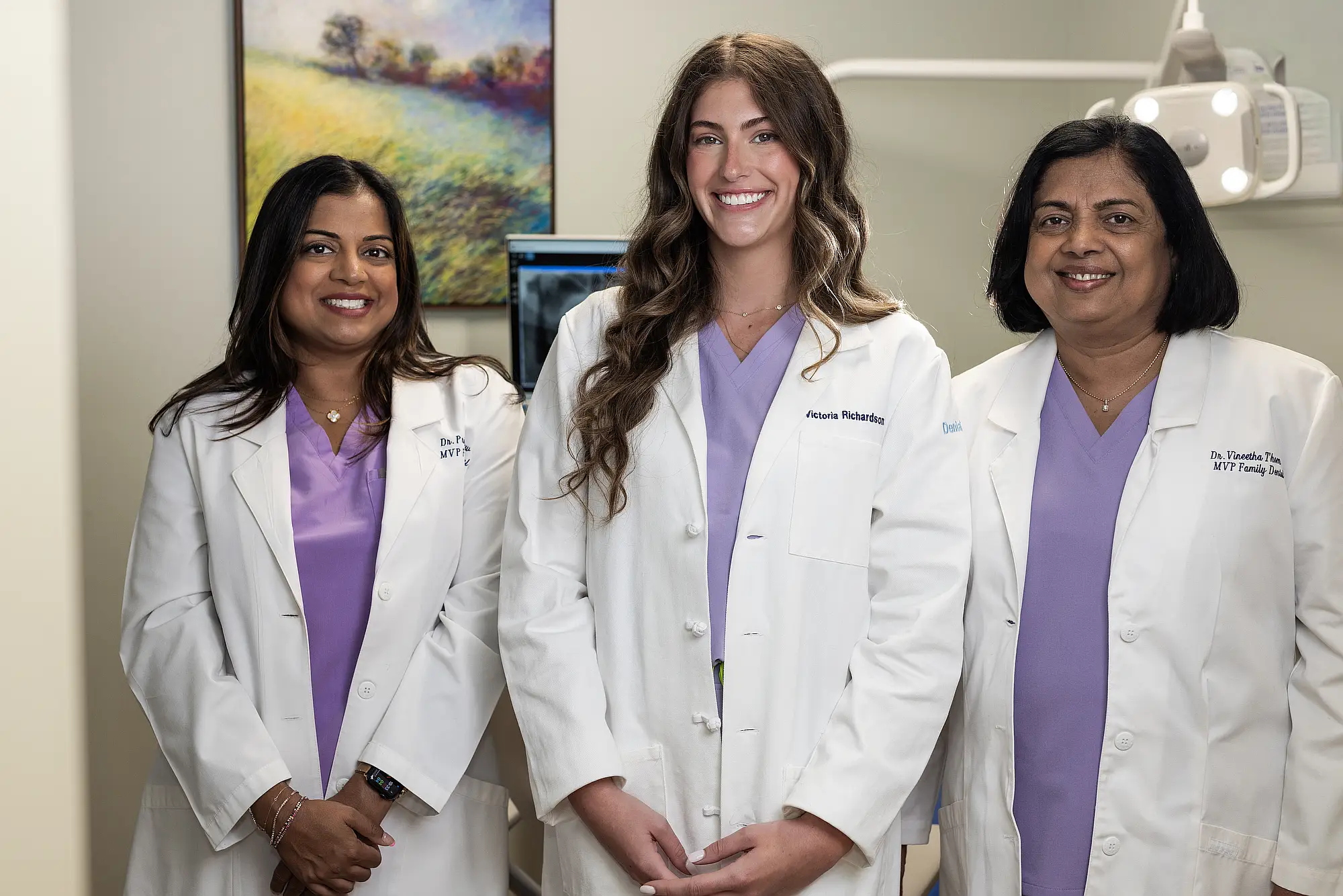 The three MVP Family Dental dentists standing together in white coats