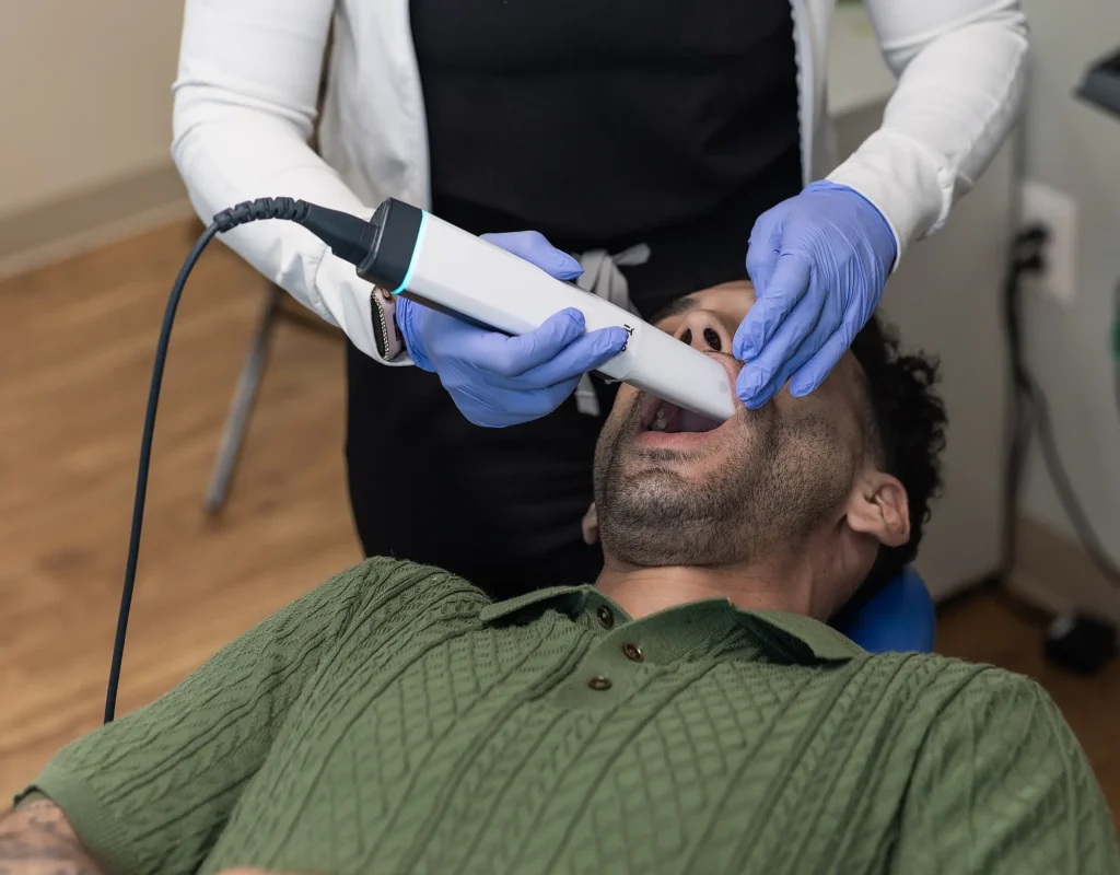 Clinician using an intraoral scanner on a patient in a dental chair