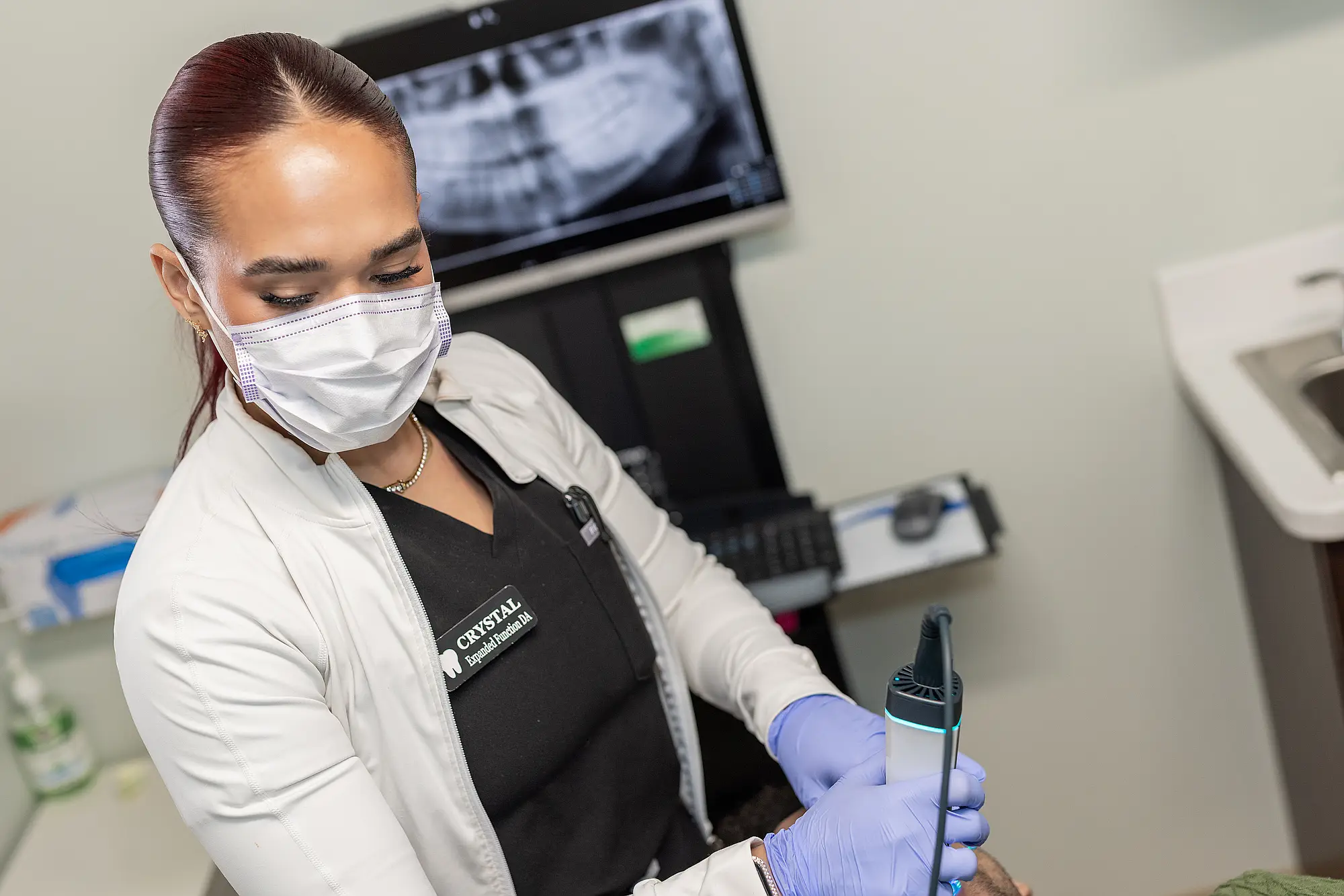 Hygienist holding an intraoral scanner in a treatment room