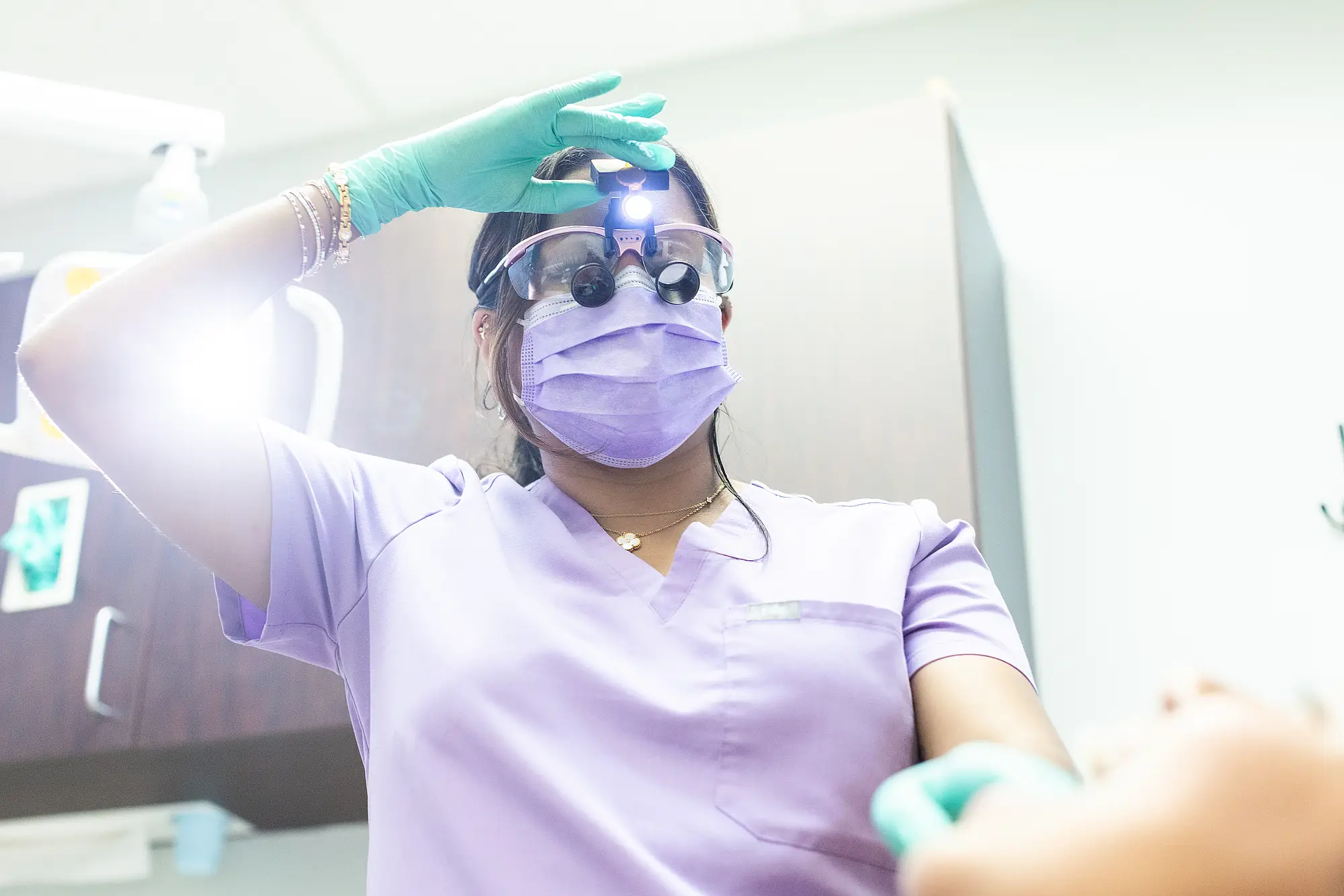 Hygienist adjusting her loupes in a treatment room