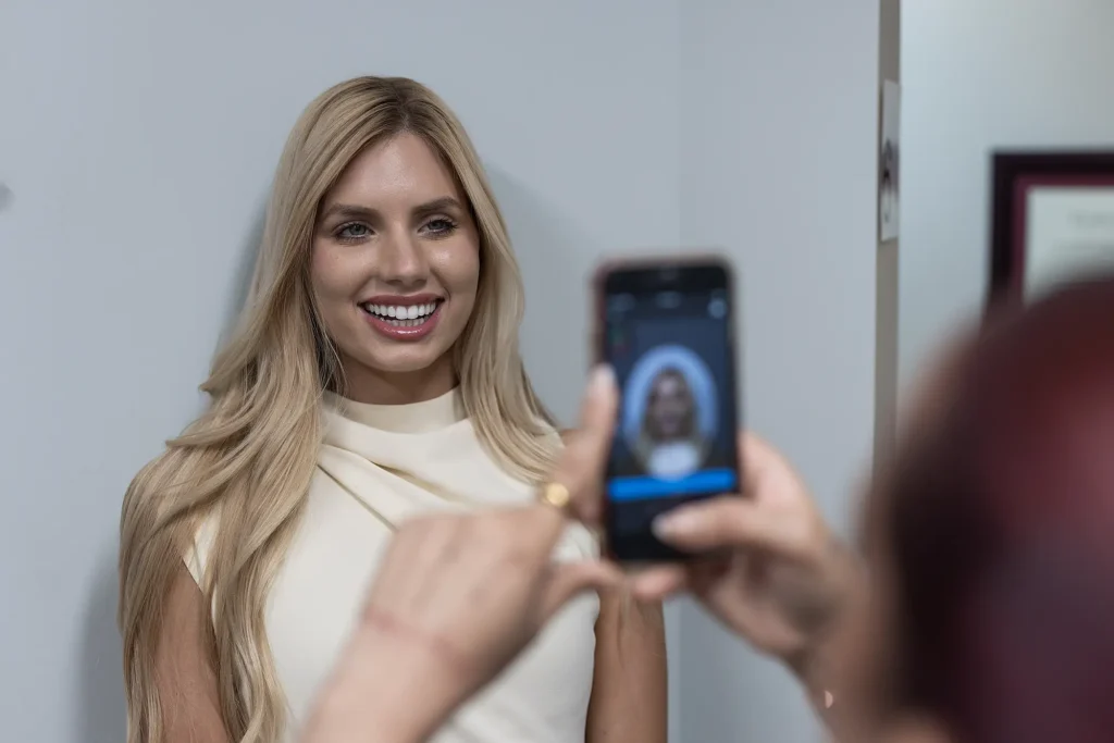 Patient having a photograph of her smile taken on a phone