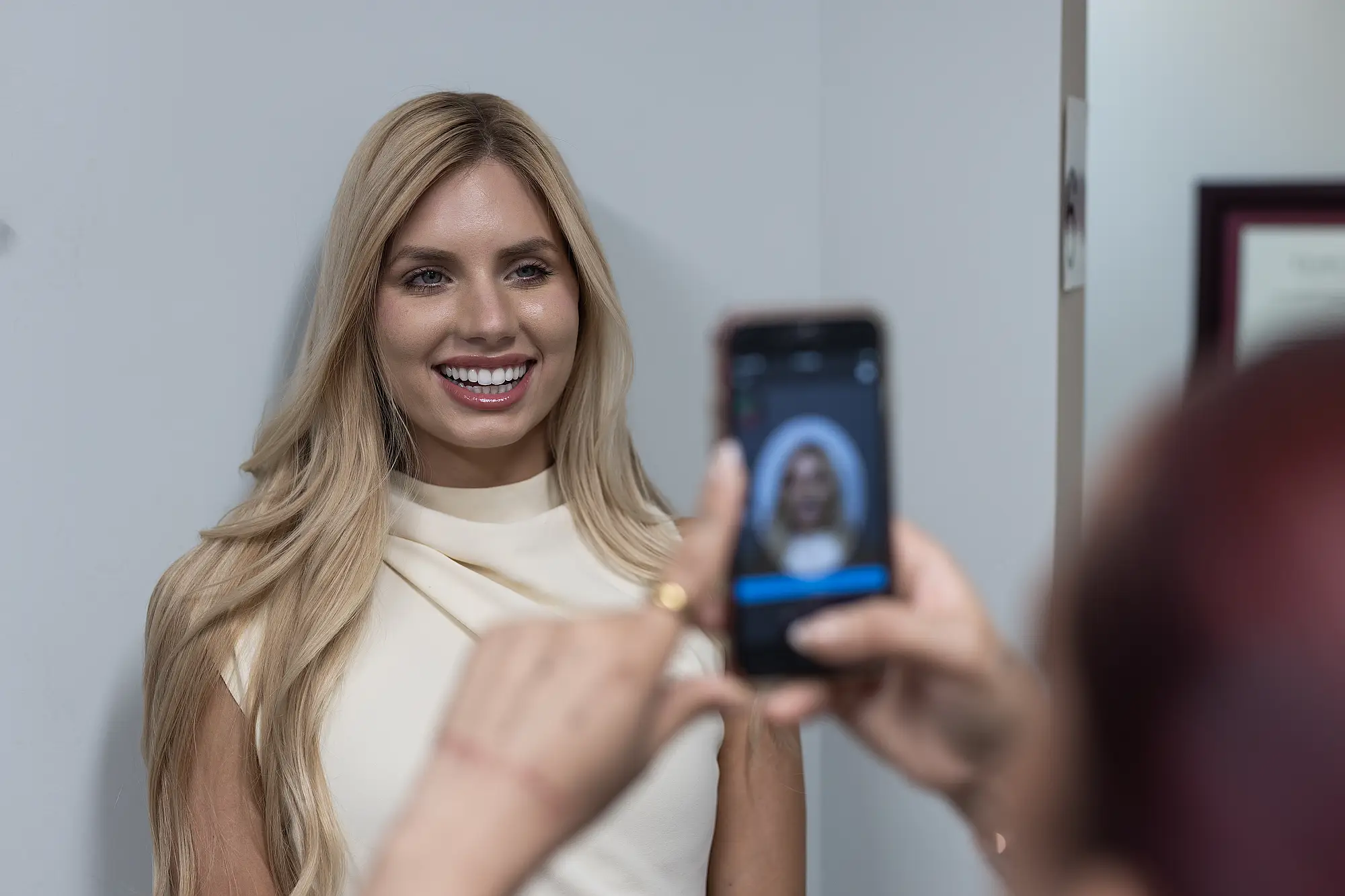 Patient having a photograph of her smile taken on a phone