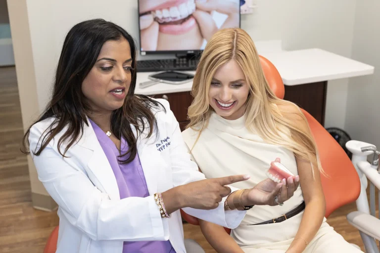 Dr. Priya Mathew pointing at an aligner model with a patient