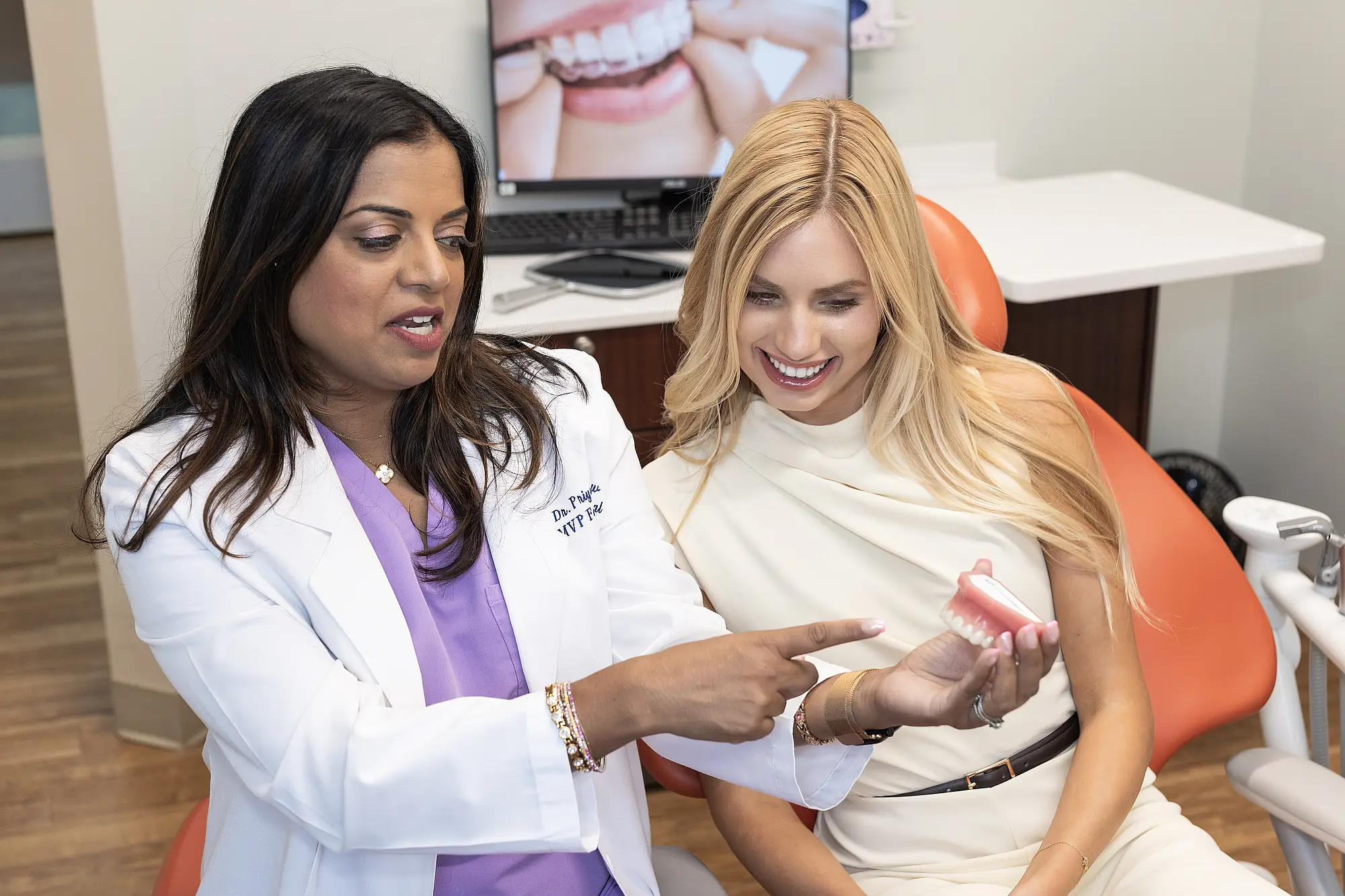 Dr. Priya Mathew pointing at an aligner model with a patient