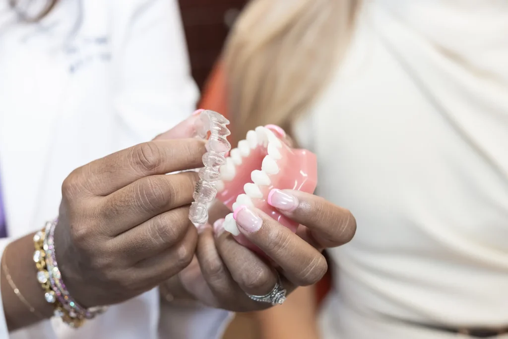 Close-up of clear aligners held over a dental model