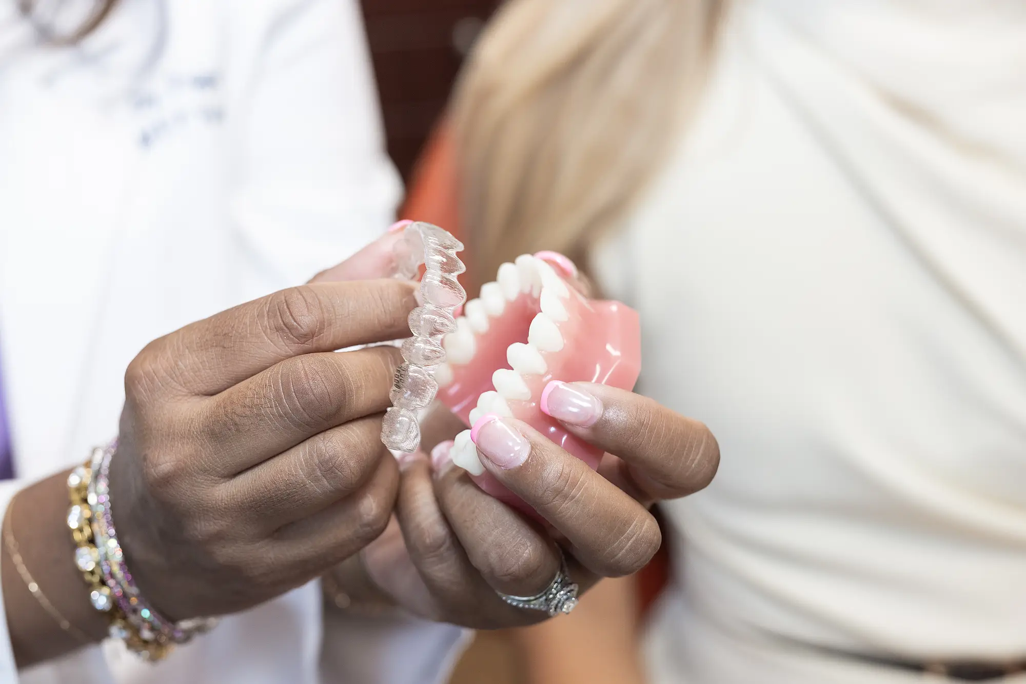 Close-up of clear aligners held over a dental model