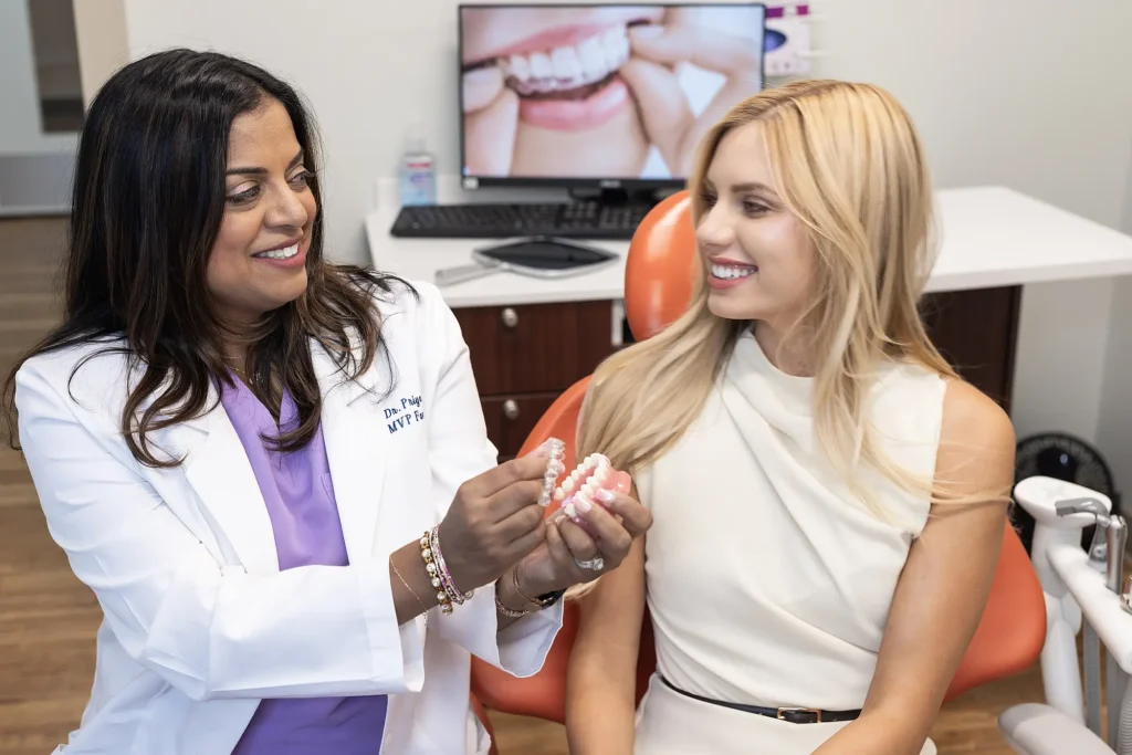 Dr. Priya Mathew handing a clear aligner model to a patient