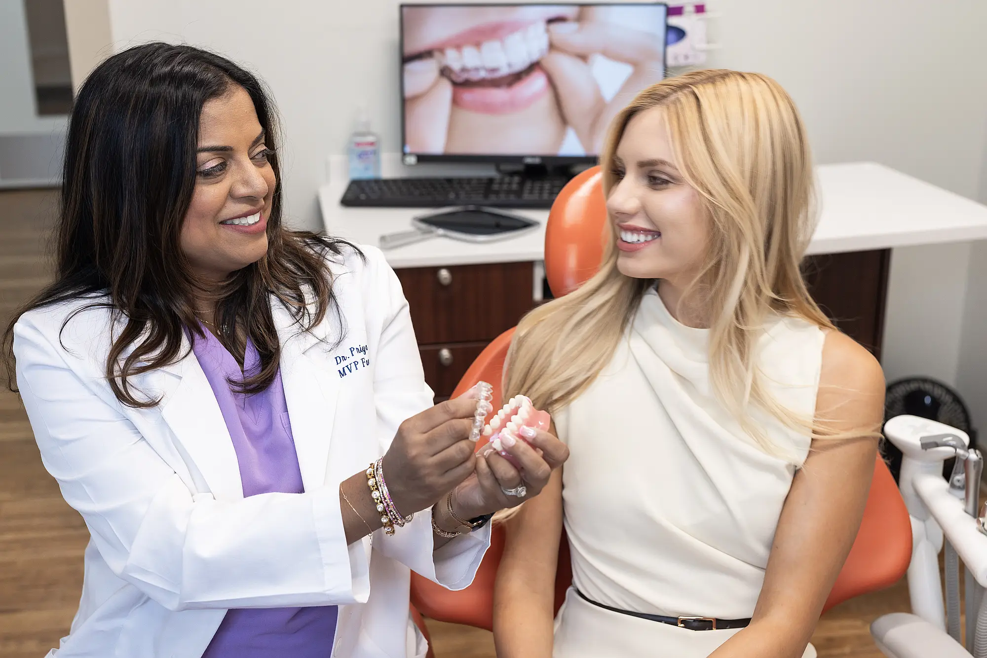 Dr. Priya Mathew handing a clear aligner model to a patient