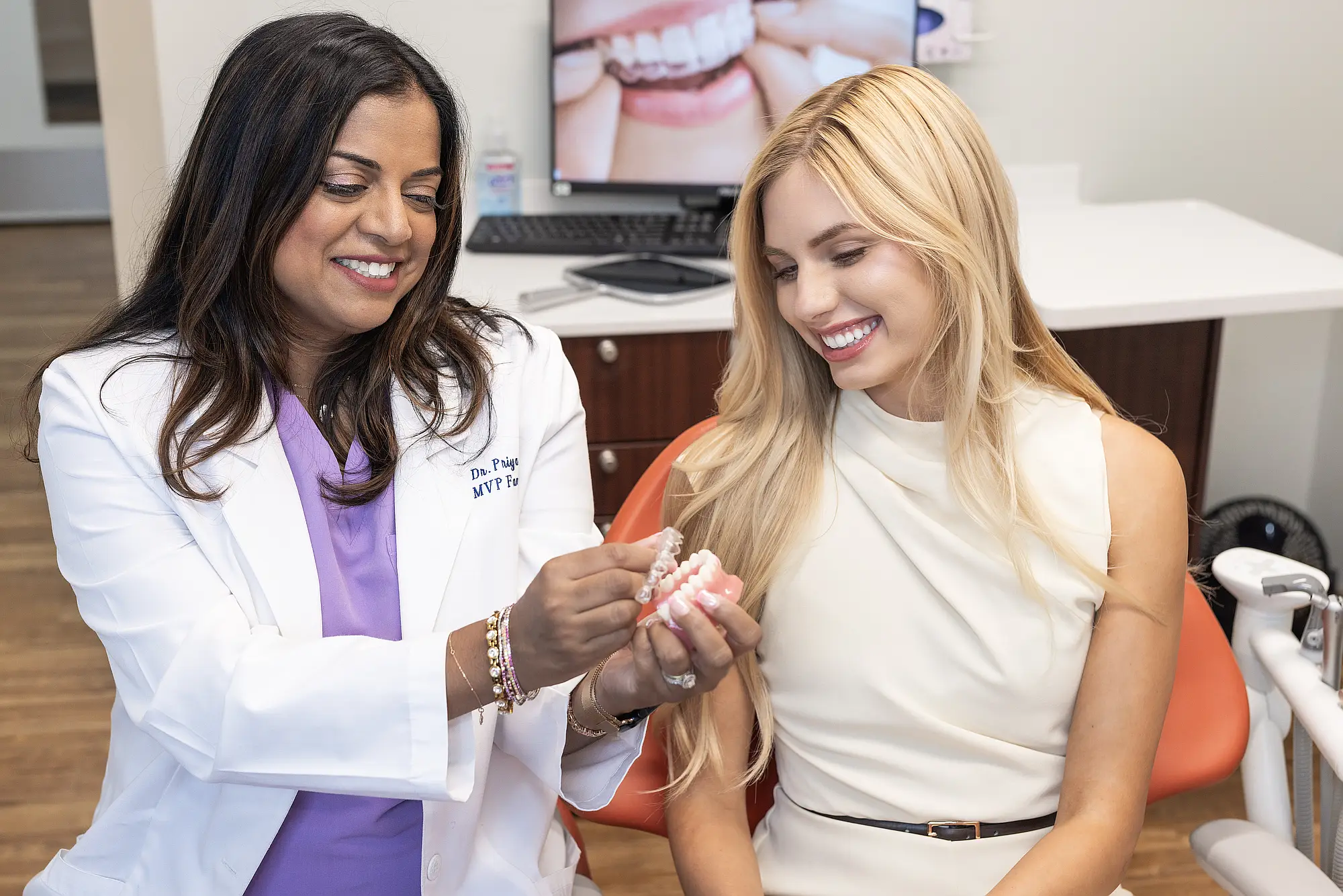 Dr. Priya Mathew and a patient examining a clear aligner model
