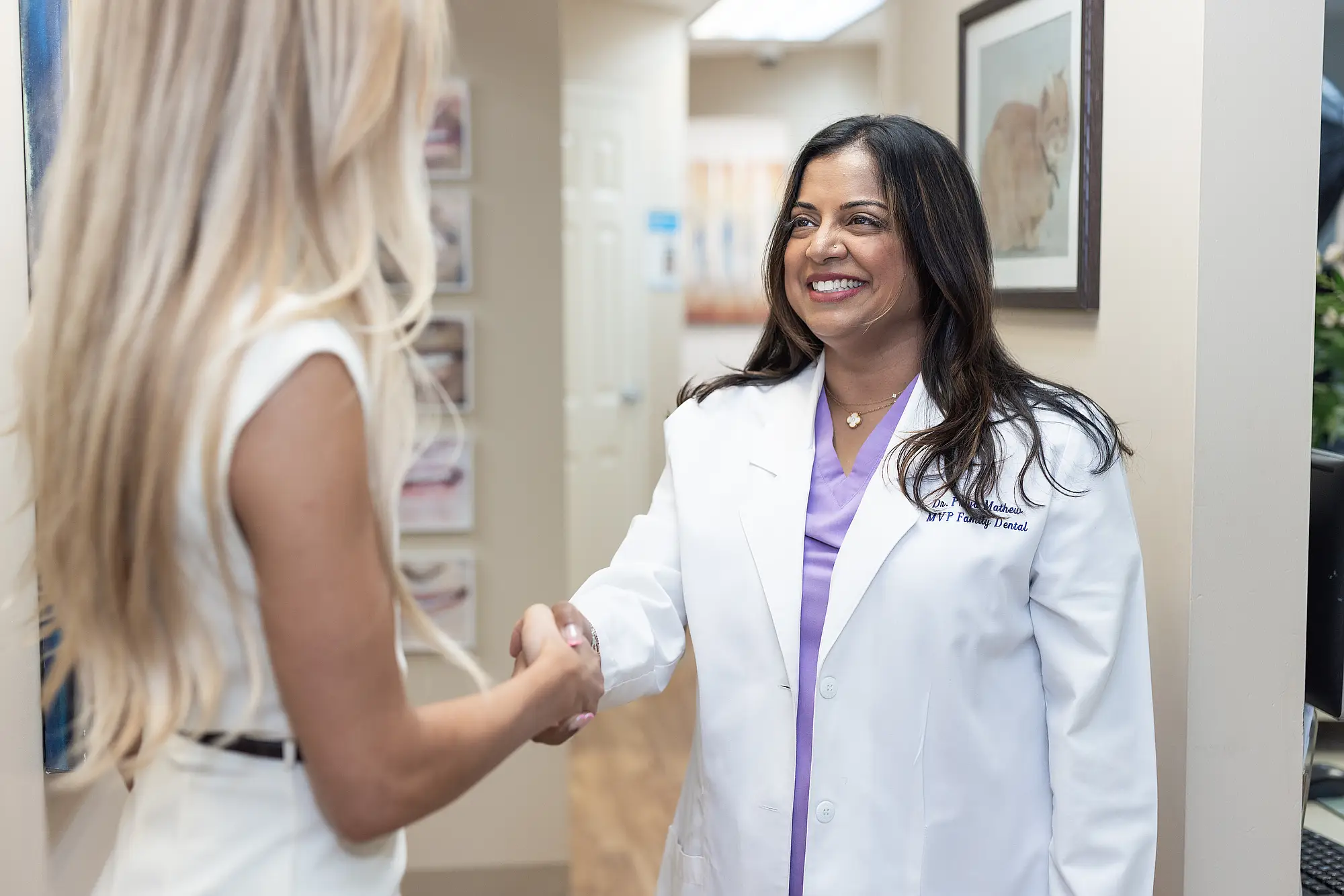 Dr. Priya Mathew shaking hands with a patient